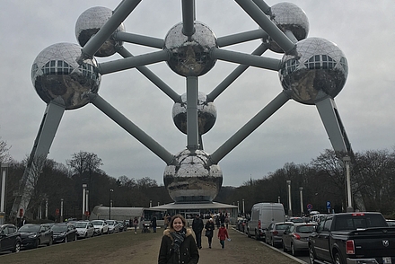 Frau steht draußen vor einem Wahrzeichen in Brüssel.