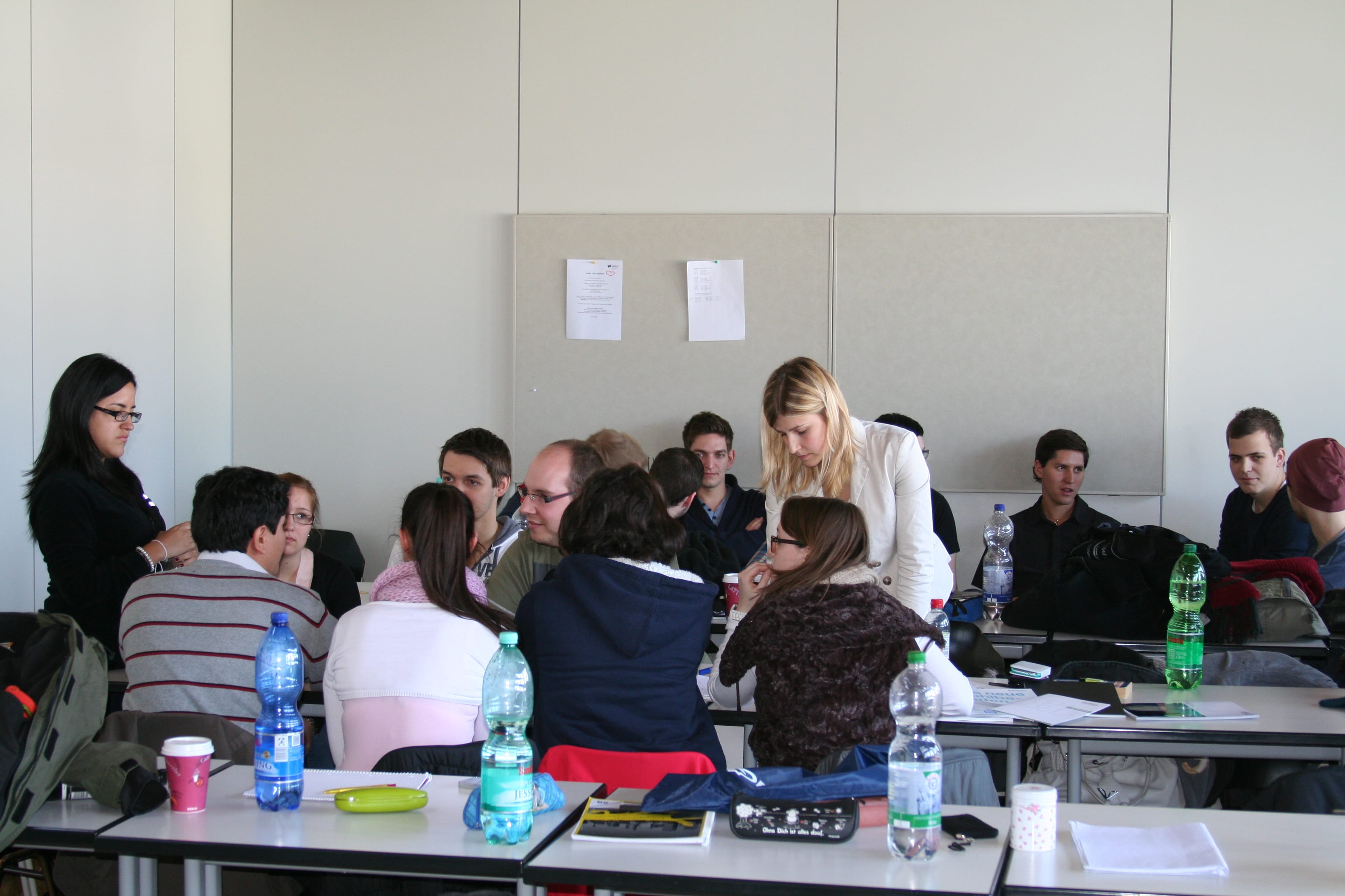 Studierende sitzen in Gruppen im Seminarraum zusammen